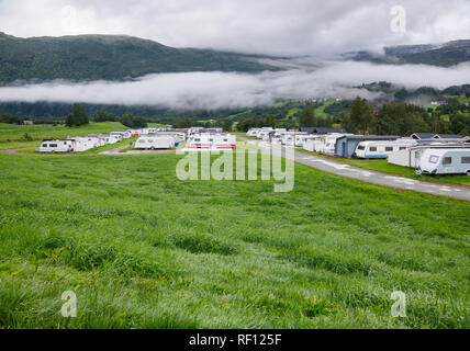 Camper Trailer und Kabinen im Holiday Park in Norwegen Skandinavien mit Blick auf Gebirge. Stockfoto