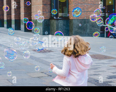 Ein junges Mädchen spielen in zwischen Blasen in London Stockfoto