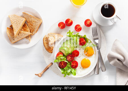 Gesundes Frühstück flach. Spiegelei, Avocado, Tomate, Toast Stockfoto