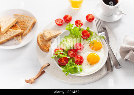 Gesundes Frühstück mit Spiegelei, Avocado, Tomaten, Toast und Kaffee Stockfoto