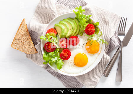 Gesundes Frühstück flach. Spiegelei, Avocado, Tomate, Toast Stockfoto