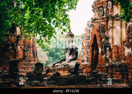 Thailand, Ayutthaya, Buddha Statue umgeben von Backstein pagodes im Wat Mahathat Stockfoto