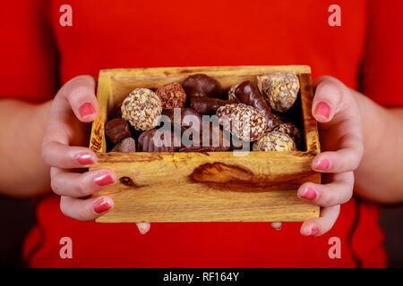 Junge fröhliches Mädchen holding Pralinen in Geschenkbox Stockfoto