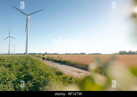 Ingenieur gehen auf Feld Pfad zu einem Windpark Stockfoto