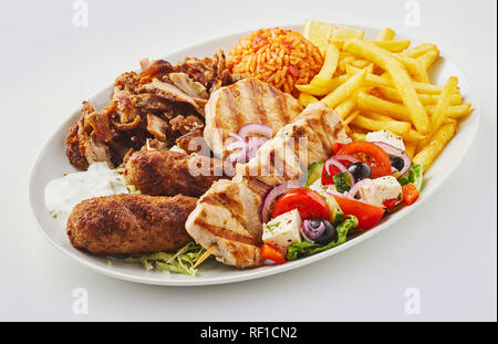 Griechische Mixed Grill platter mit Salat, domatorizo und Pommes Frites und eine Auswahl an Souvlaki, souzuki Steaks und gegrilltem Schweinefleisch Spieße Stockfoto