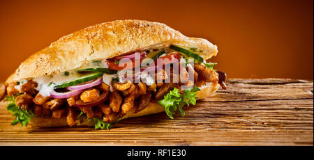 Großes Brot Sandwich mit Gemüse und Fleisch auf Holz Schneidebrett Stockfoto