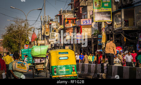 New Delhi/Indien - 12. April 2017: beschäftigte Straße Chandni Chowk in Old Delhi Innenstadt mit Massen von Menschen, gelb Rikschas. Stockfoto