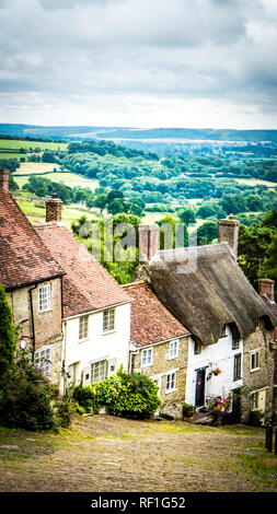 Gold Hill in Shaftesbury ist ein authentischer Ort im Süden von Deutschland. Blick auf einen Stein alten gepflasterten Straße auf einem Hügel mit alten englischen Kalkstein Häuser. Stockfoto