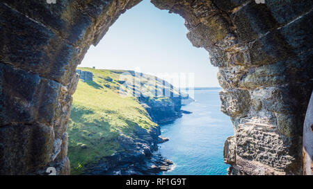 Ruinen von einer Tür von Tintagel Castle des legendären König Artus in Cornwall, England, Großbritannien. Tintagel Castle Eingang Ruinen mit Cornish Landschaft Stockfoto