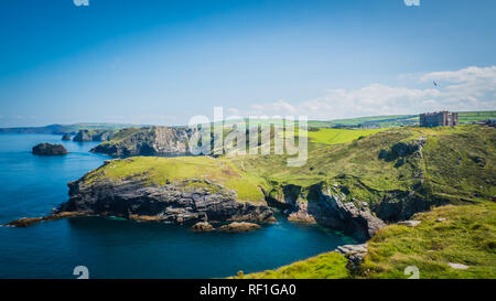 Merlin's Cave, Grün felsigen Klippen, dramatische Landschaft mit Atlantik/Keltische See Blick von Burg Tintagel in Cornwall, Großbritannien Stockfoto