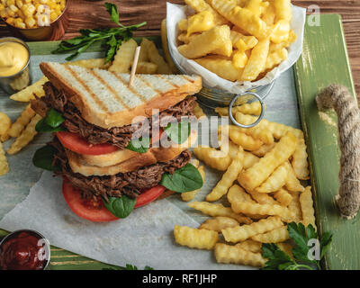 Beef sandwich gezogen, Barbeque, Toastbrot, Pommes Frites, Sauce, Mais auf einer hölzernen Fach Stockfoto