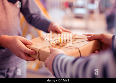 Im Mittelpunkt Foto Geschenk Box, die sich in Händen Stockfoto