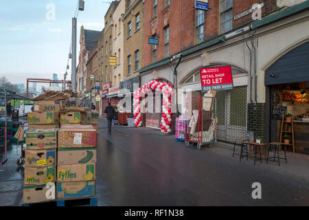 Der Whitechapel Road in den frühen Morgen als die Straße Markt öffnet, die Ballons auf dem shop der Eröffnung verkünden Stockfoto