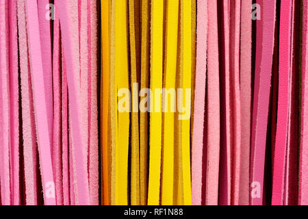 Ausschnitt Textur closeup auf mehrere Rosa und Gelb bunte Lederbändern. Stockfoto