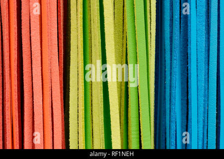 Ausschnitt Textur closeup auf mehrere orange, grün und blau bunt Lederbändern. Stockfoto