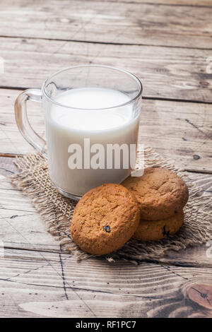 Natürliche Haferflocken Kekse und ein Glas Milch auf einem hölzernen Hintergrund. Im rustikalen Stil kopieren Raum Stockfoto