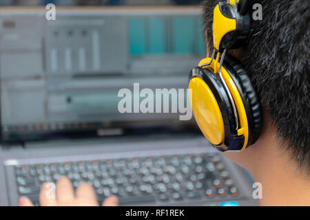 Videobearbeitung, Computer, Laptops und Kopfhörer. mit Laptop. Professionelle editor besondere Effekte hinzufügen oder Farbkorrektur footage. Rückansicht des Jungen m Stockfoto