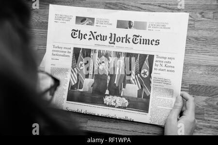 PARIS, Frankreich, 13. JUNI 2018: die Frau mit der New York Times im Büro, auf dem Cover der US-Präsident Donald Trump Sitzung nordkoreanischen Führer Kim Jong-un-in Singapur Stockfoto