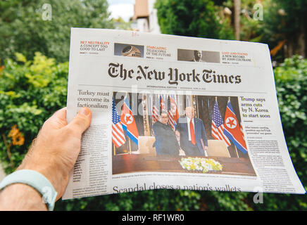 PARIS, Frankreich, 13. JUNI 2018: der Mann, der das Lesen der New York Times zeigt auf dem Cover der US-Präsident Donald Trump Sitzung nordkoreanischen Führer Kim Jong-un-in Singapur Stockfoto