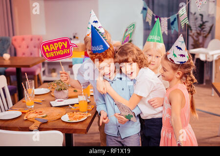 Positiv erfreut Kinder unter Foto mit Geburtstagskind Stockfoto