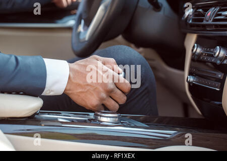 Junge Unternehmer Fahrer sitzt im Auto Holding Gear shifter close-up Stockfoto