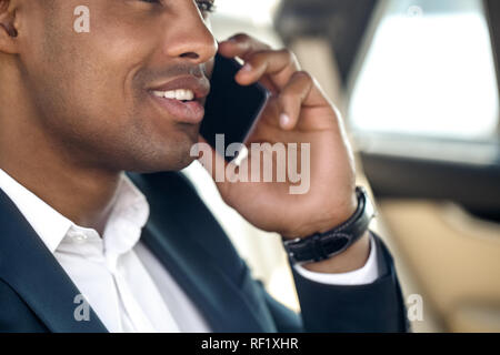 Junge Unternehmer im Auto sitzen Reden auf dem Smartphone close-up heiter Stockfoto