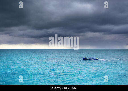 Fischer Boot segeln bei stürmischem Wetter in tropischen türkisfarbenem Wasser, flachkopfkatze, Japan Stockfoto