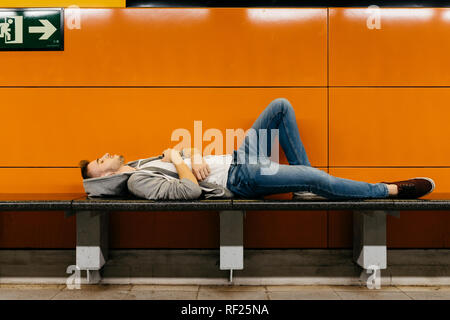 Junger Mann warten auf die U-Bahn, ruht auf der Werkbank Stockfoto