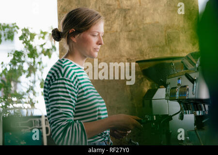 Junge Frau in einem Cafe Kaffee vorbereiten Stockfoto