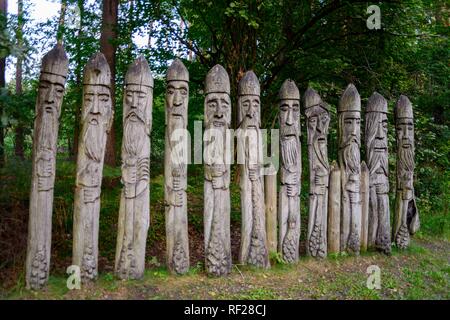 Geschnitzte Gesichter auf toten Baumstamm, Galindia, See Beldany, Iznota, Ruciane-Nida, Ermland-Masuren, Polen Stockfoto