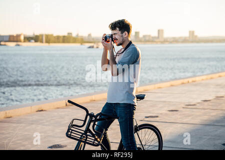 Junger Mann mit Pendler fixie Bike ein Bild am Flußufer Stockfoto