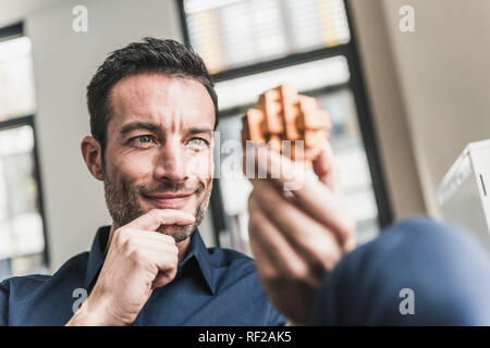 Reifer Mann im Büro Montage Holz- cube Puzzle Stockfoto