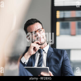 Geschäftsmann mit digitalen Tablet, im Büro mit Füßen bis Stockfoto