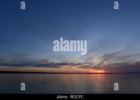 Leuchtende Sonnenlicht in das klare blaue Dämmerung Himmel in der Stille der Sommerabend vor Einbruch der Dunkelheit auf einem See Stockfoto