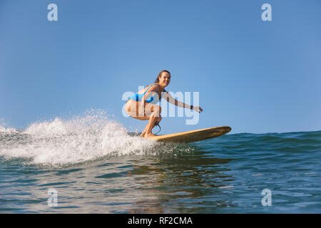 Indonesien, Bali, Batubolong Strand, schwangere Frau, Surfer im Ozean Stockfoto