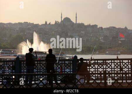 Fischer auf der Galata Brücke über das Goldene Horn, eine zweistöckige Brücke mit einer Straße über und Bars und Restaurants unter Stockfoto