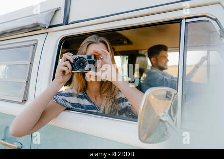 Frau unter Bild Fenster von einem Wohnmobil mit man fahren Stockfoto