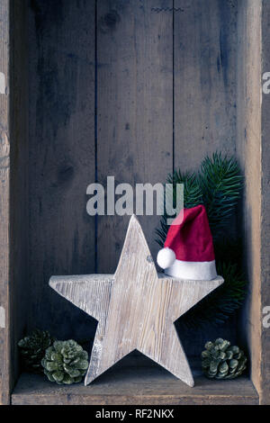Weihnachtsdekoration Weihnachtsmann Hut auf einem Stern in einer Holzkiste Hintergrund Stockfoto