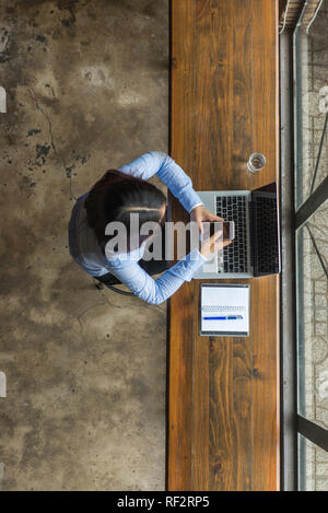 Junge asiatische Frau mit Smartphone für Arbeit Stockfoto
