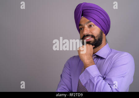 Indische Sikh Geschäftsmann, tragen Turban beim Denken Stockfoto