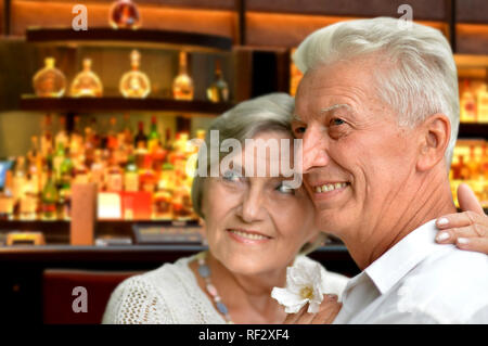 Portrait von Happy senior Paar posiert auf unscharfen Bar Inneneinrichtung Hintergrund Stockfoto