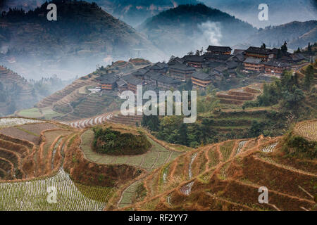 Häuser auf Anhöhe über Reisterrassen auf die Berghänge von Longshen, China Stockfoto