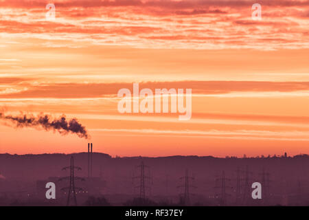 London, Großbritannien. 24. Januar 2019. Rauch aufsteigt, aus einem Schornstein gegen einen dramatischen bunte Himmel während eines Winters Sonnenaufgang in Wimbledon Credit: Amer ghazzal/Alamy leben Nachrichten Stockfoto