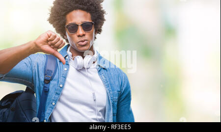 Afro-amerikanischer Mann mit Kopfhörern und Rucksack über isolierte Hintergrund mit Verärgerten Gesicht, negatives Vorzeichen zeigen Abneigung mit Daumen nach unten, Ablehnung Stockfoto