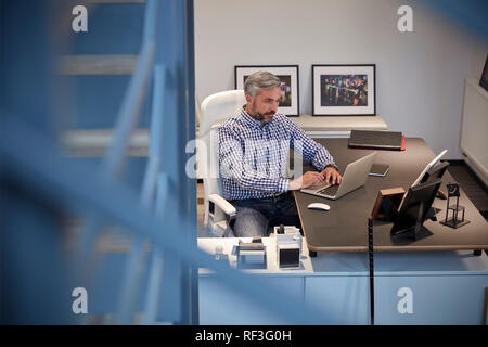 Geschäftsmann, sitzen im Büro, am Laptop arbeiten Stockfoto