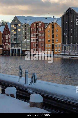 Alte hölzerne Gebäude, Zeitschriften, am Ufer des Flusses Nidelva, Winter in Trondheim, Norwegen. Stockfoto