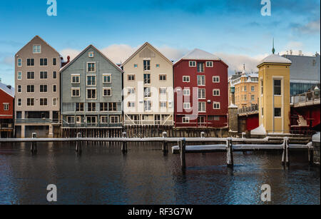 Alte hölzerne Gebäude, Zeitschriften, am Ufer des Flusses Nidelva, Winter in Trondheim, Norwegen. Stockfoto