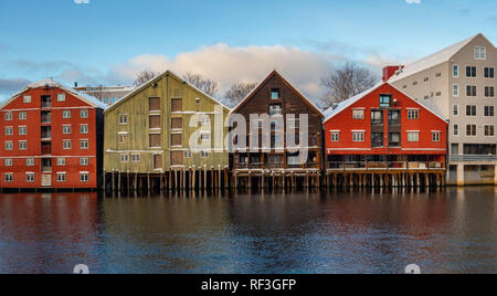 Alte hölzerne Gebäude, Zeitschriften, am Ufer des Flusses Nidelva, Winter in Trondheim, Norwegen. Stockfoto