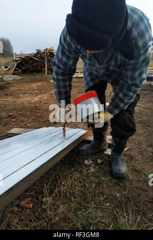 Ein Mann malt eine weiße Tafel mit einem Pinsel 2019 Stockfoto