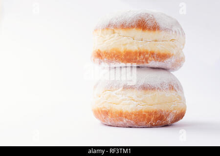 Zwei frisch gebackenen Donuts, übereinander gestapelt, mit Marmelade gefüllt und in Puderzucker bedeckt auf weißem Hintergrund Stockfoto